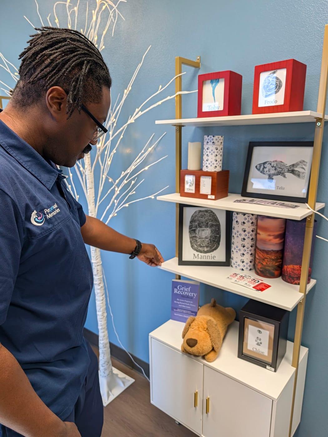 Donato at the facility, setting out urns, paw prints and keepsakes on the display shelves
